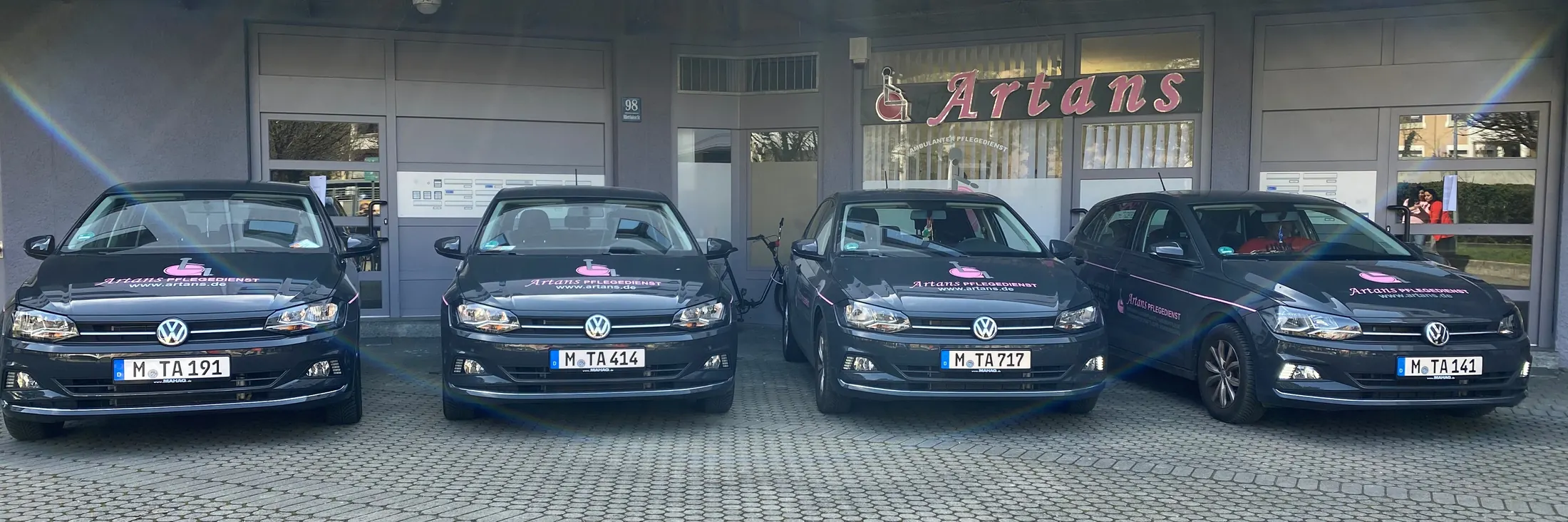 Vier Dienstwagen mit Artans-Beschriftung vor dem Büro
